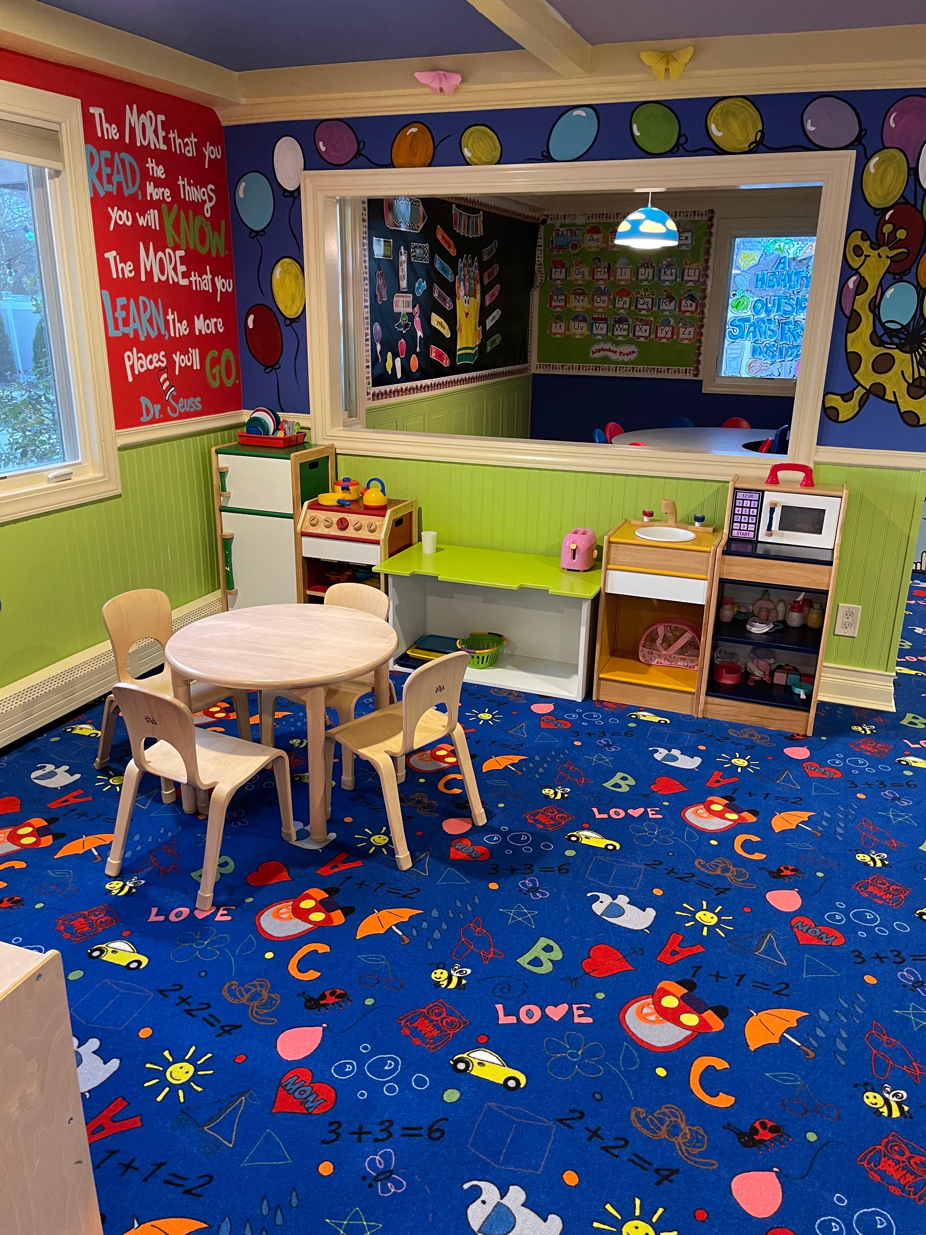 Reading corner with Dr. Seuss quote and play kitchen area